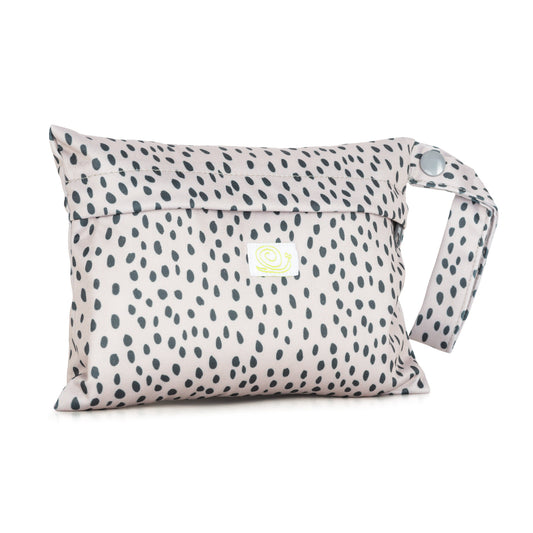 Mini wet bag featuring a zip and handle. It is a pale bag with black spots all over.