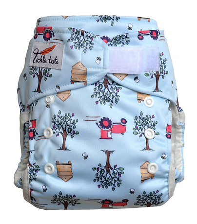 Reusable cloth nappy with tractor print and velcro fastening.