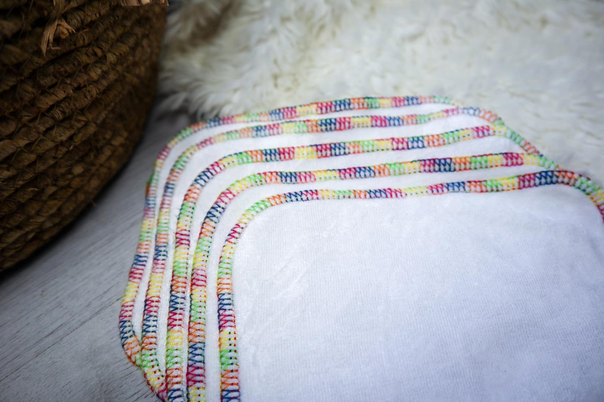 Image showing 5 reusable cloth wipes with a rainbow trim.