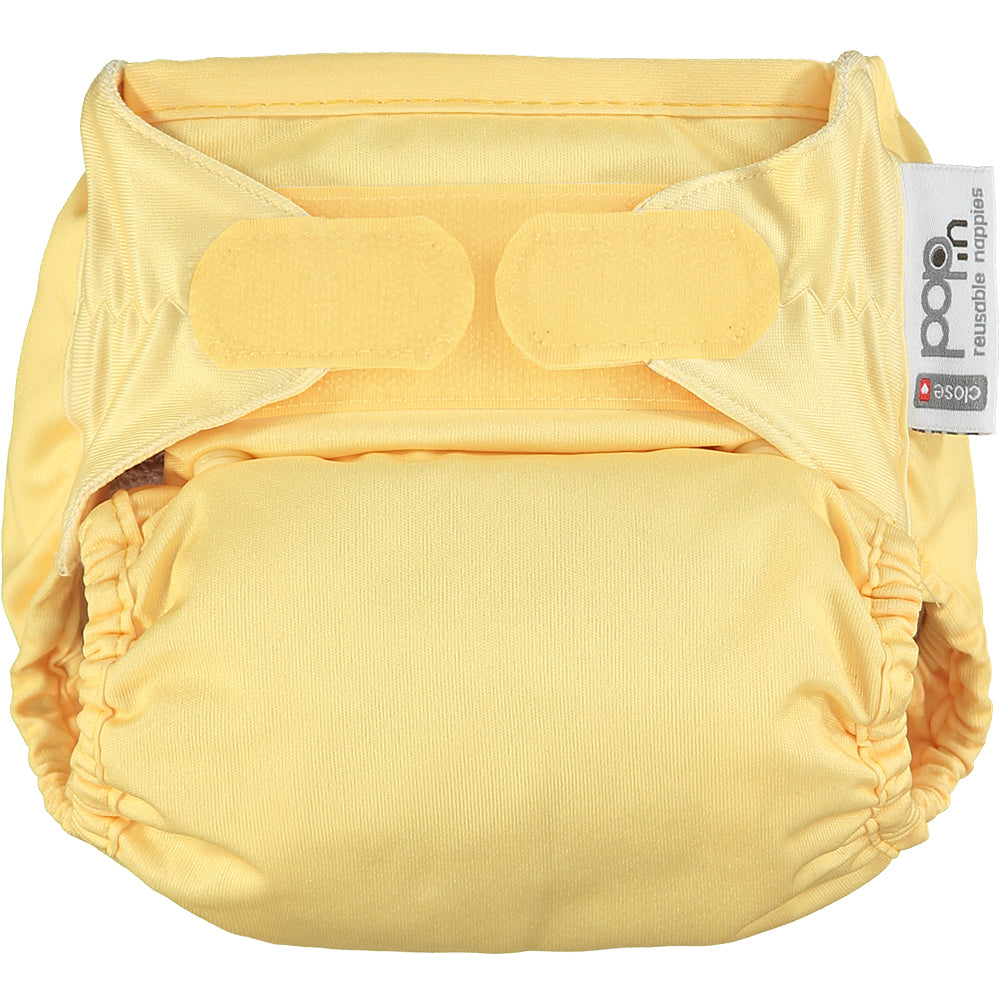 Image shows a pale yellow reusable cloth nappy with velcro fastening.