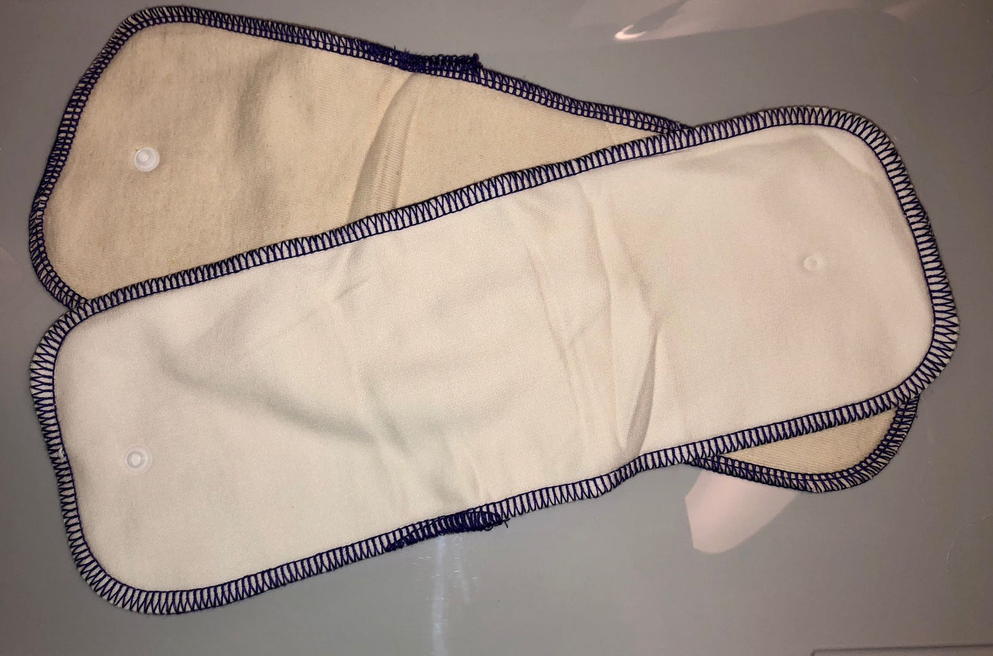 Image showing two inserts that come with fitted nappy with a purple trim.